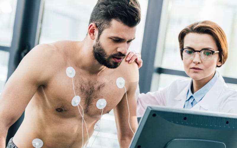 doctor conducting endurance test with sportsman in gym